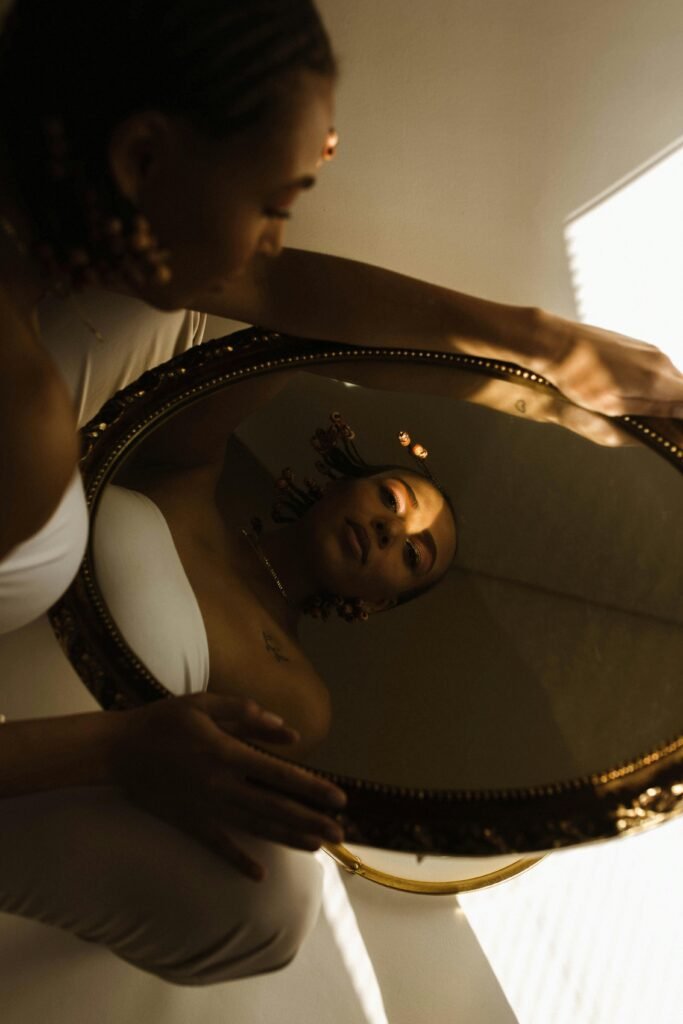 mirror.jpg A woman looking at her reflection in an ornate mirror, symbolizing self-identity.